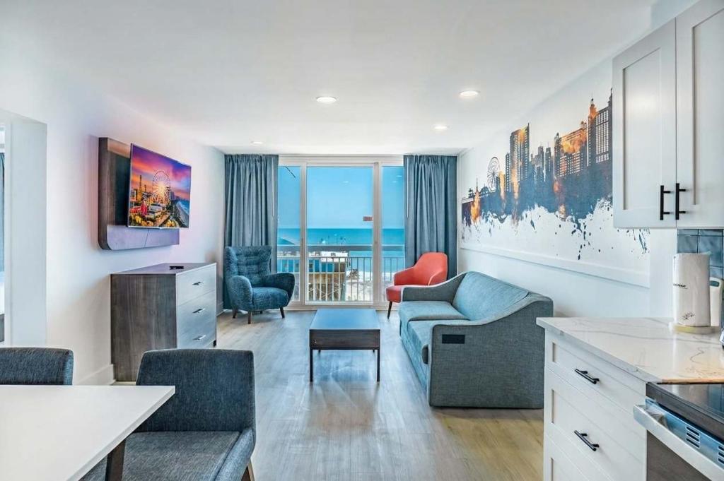a kitchen and living room with a couch and chairs at Coastal Modern Oceanfront 2BR Yachtsman S506 in Myrtle Beach