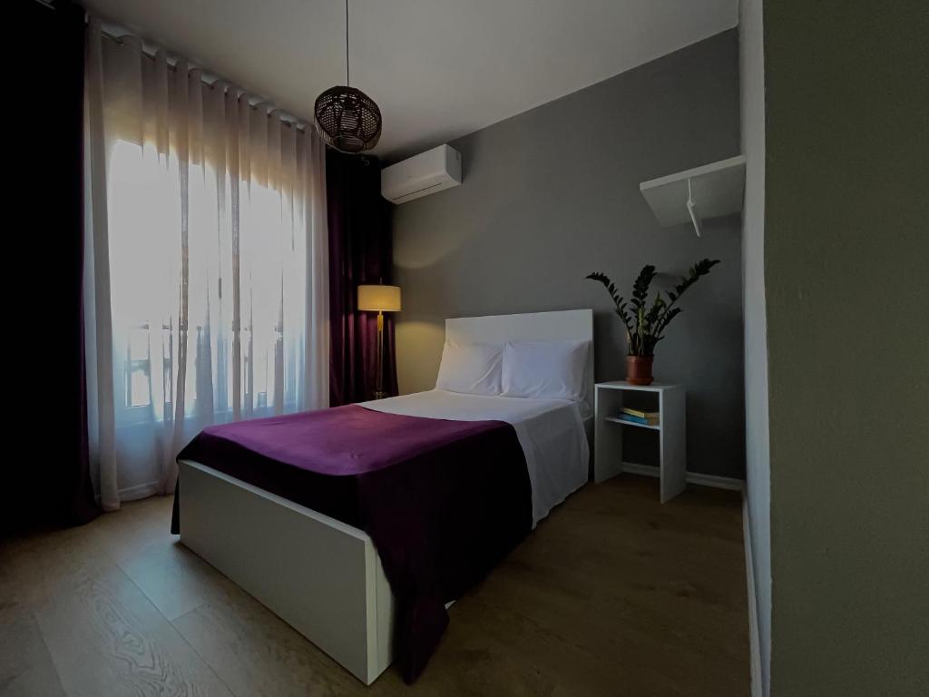a bedroom with a bed with a purple blanket at Patushe Guesthouse in Shkodër