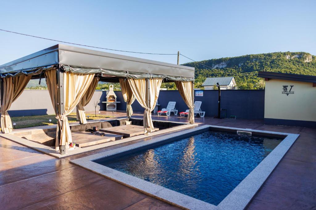 a swimming pool with a gazebo on a patio at Villa Merak House in Bijelo Brdo