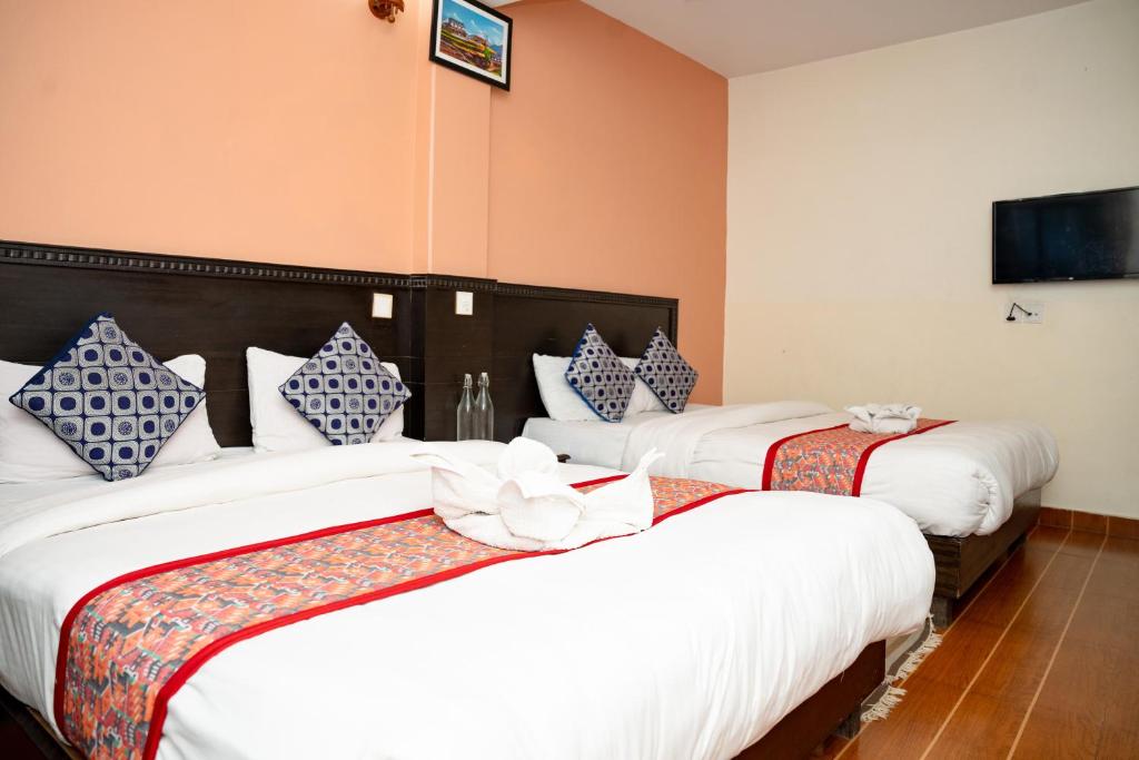 a hotel room with two beds and a tv at Admire Hotel Pvt Ltd in Pokhara
