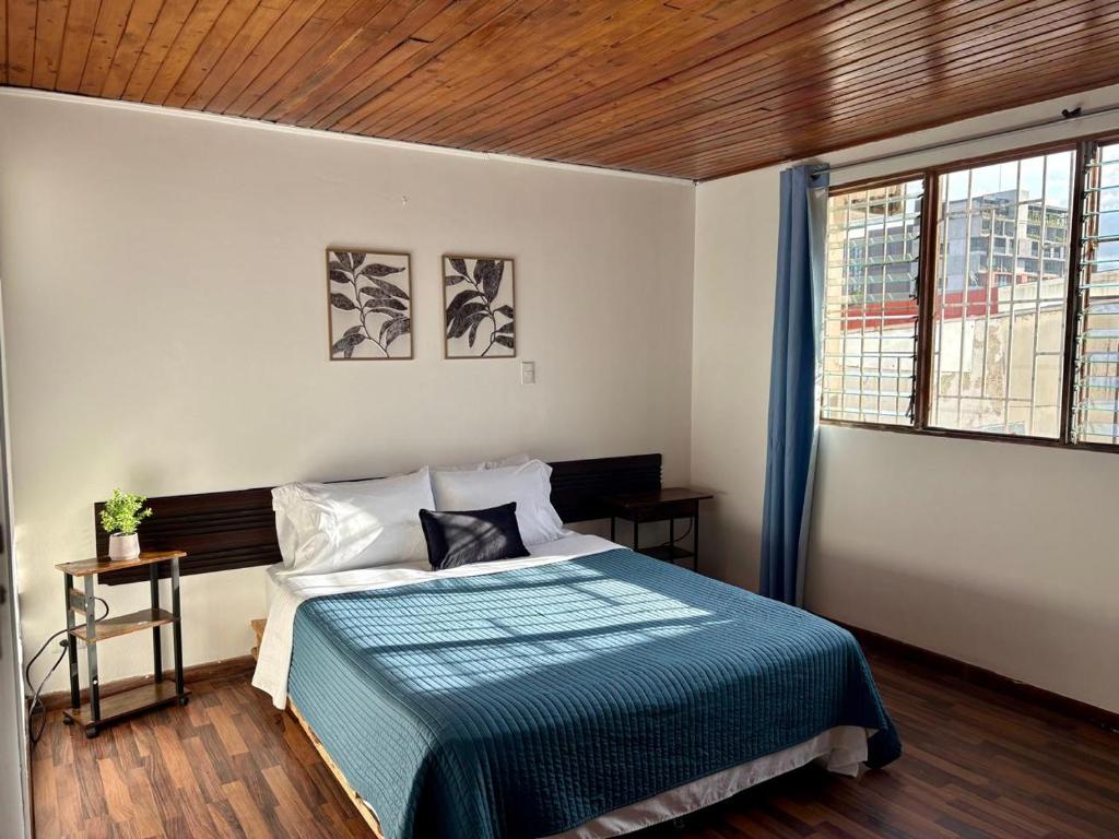 a bedroom with a bed with a blue blanket at casa luca in San José
