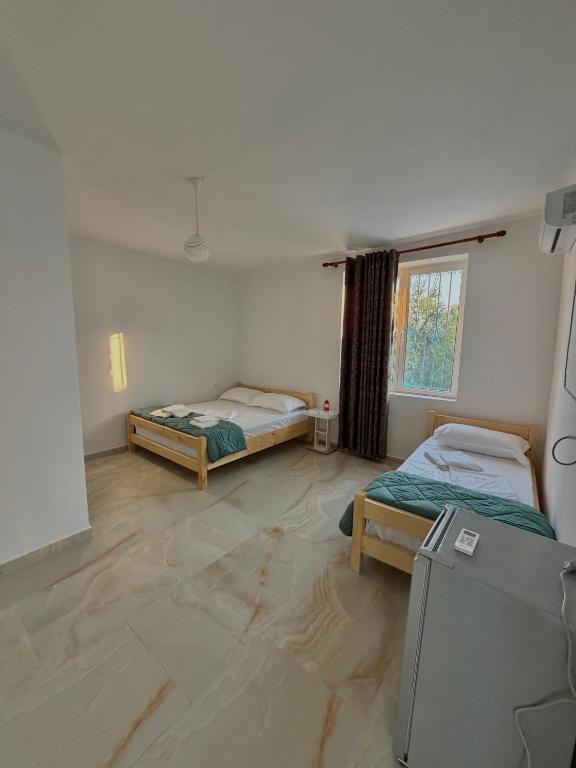 a room with two beds and a television in it at Lukova rooms in Lukovë