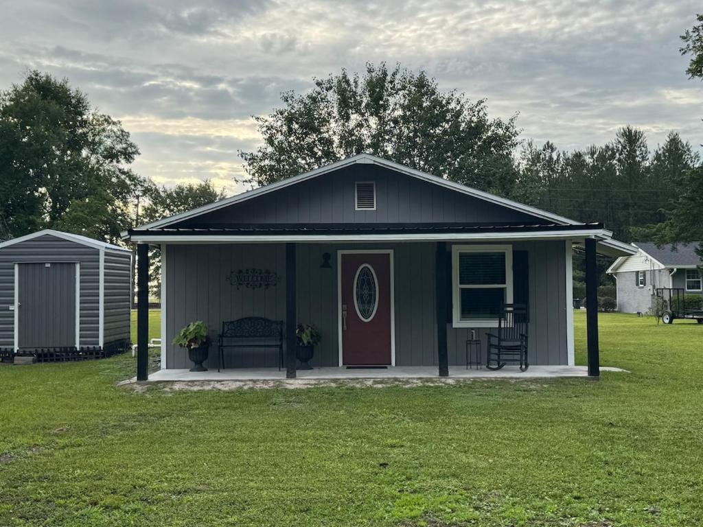 a small house with a red door in a yard at Cherry Cottage in Lake City