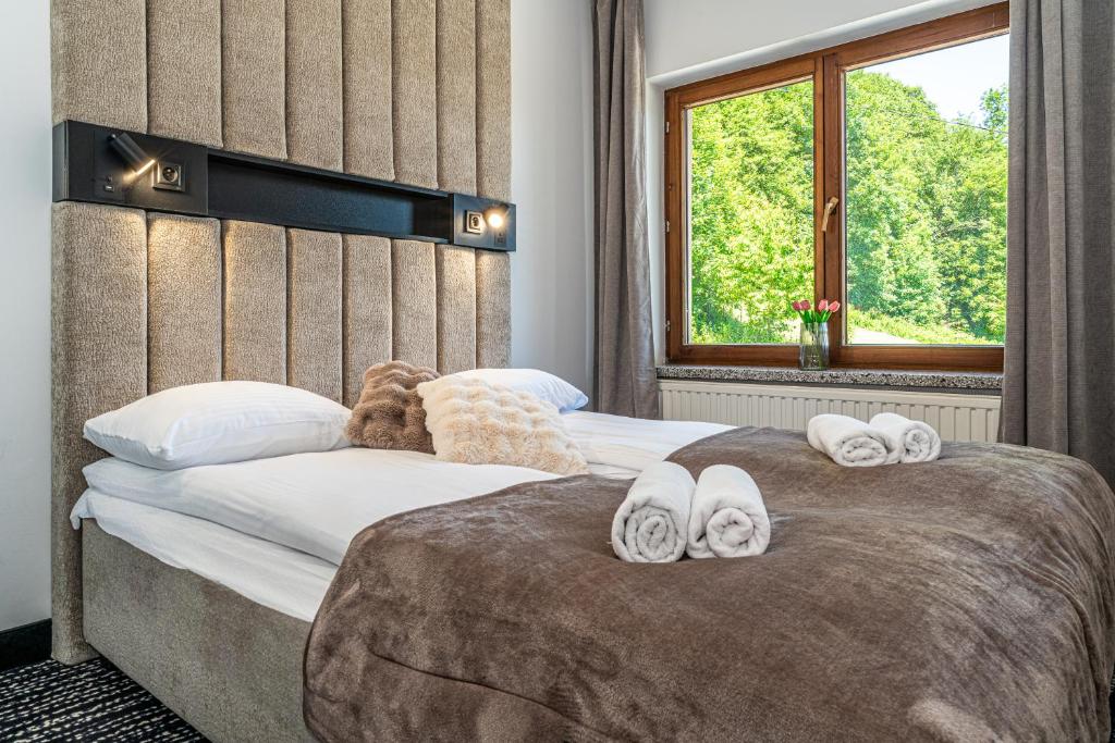 a bedroom with two beds with towels on them at Home Tatra in Biały Dunajec