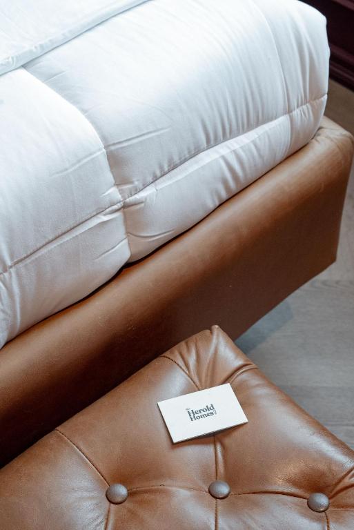 a brown leather couch with a ticket on it at The Green Escape Suite in Mexico City