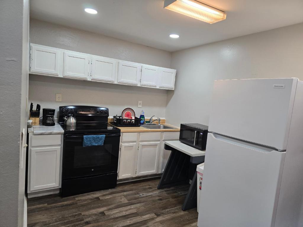 a kitchen with white cabinets and a black refrigerator at Cozy-One in Cincinnati