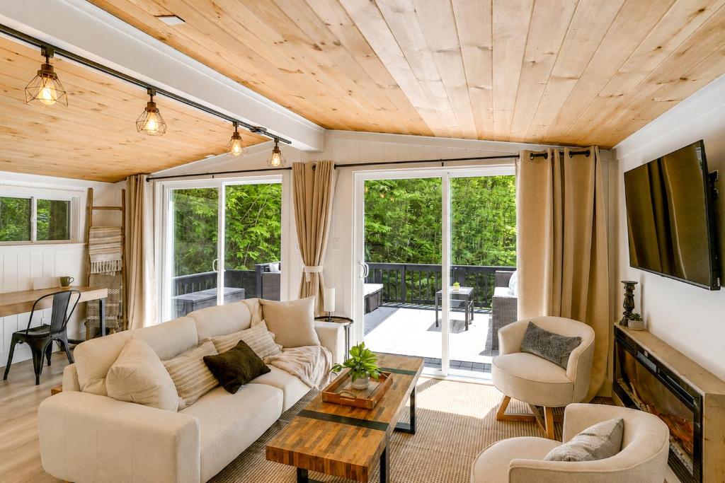 a living room with a couch and a table at High-Design Monroe Cabin on 2 Private Acres! in Readsboro