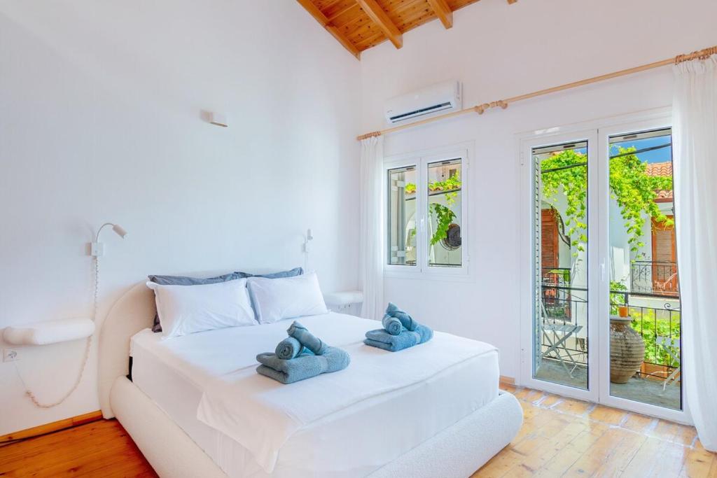 a bedroom with a white bed with two teddy bears on it at Kooreloo Airy Loft in Koroni