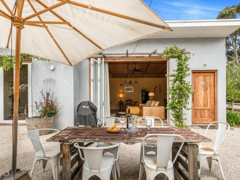a patio with a table and chairs and an umbrella at Lianna Bungalow in Auburn
