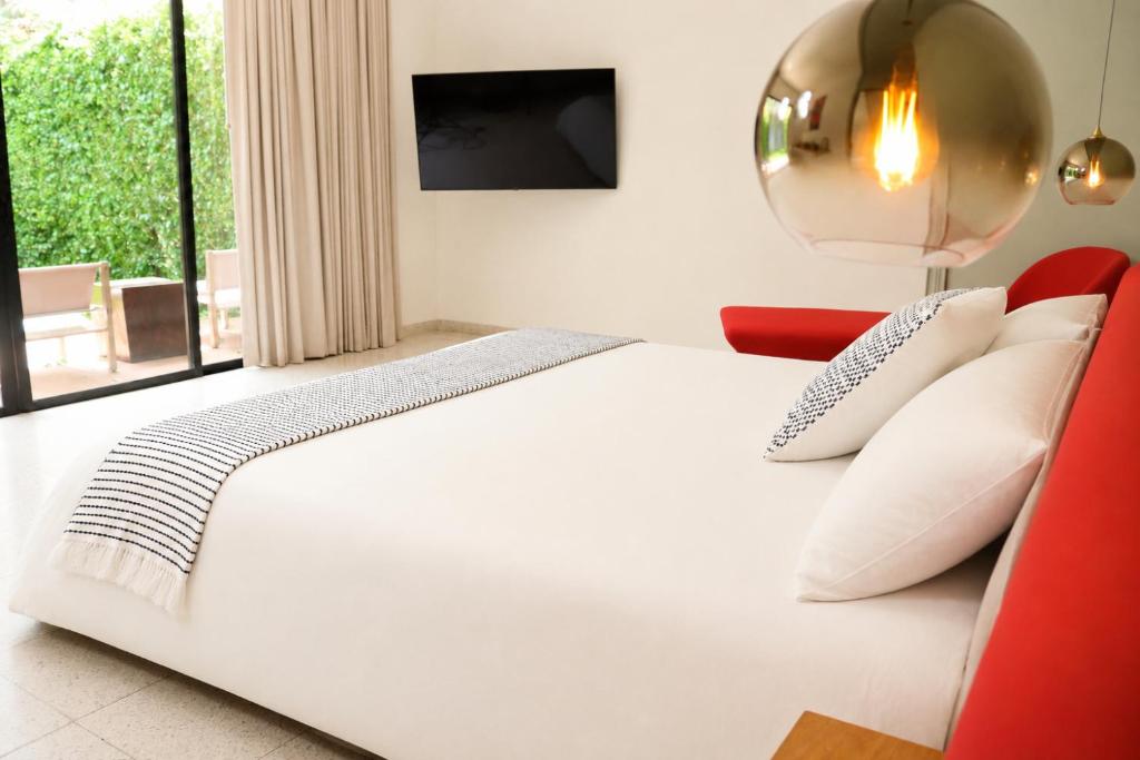 a bedroom with a white bed and a red chair at Il Buongustaio in San Salvador