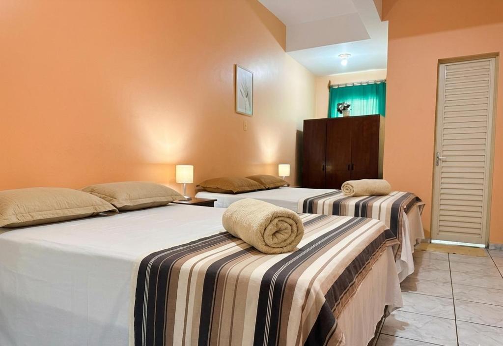 a room with two beds with towels on them at Hotel Coutinho PIO XII in Pirapora