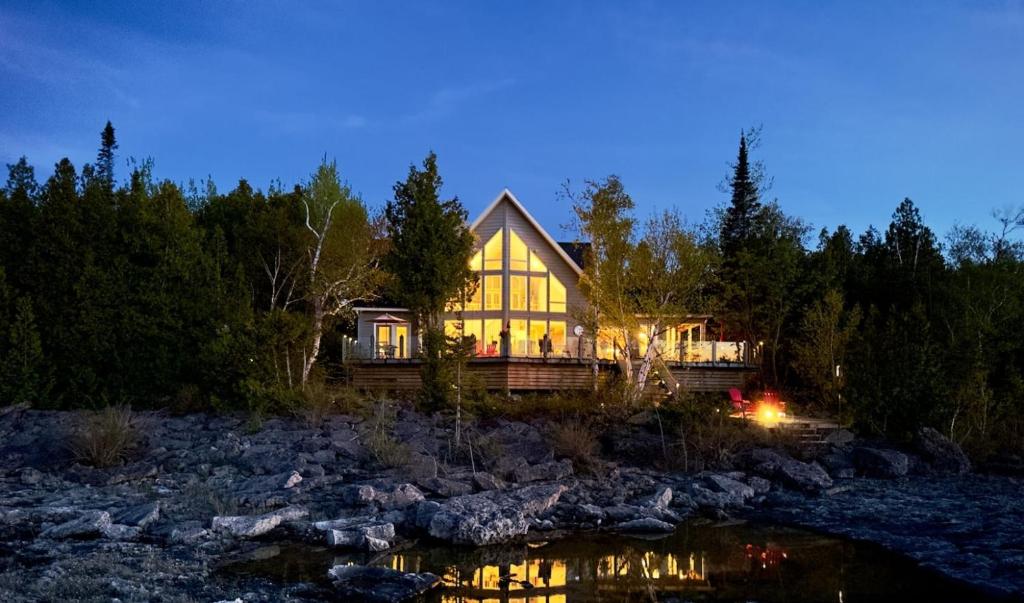 a house with a river in front of it at Waterfront 22' Windows Starlink Kayaks in Tobermory