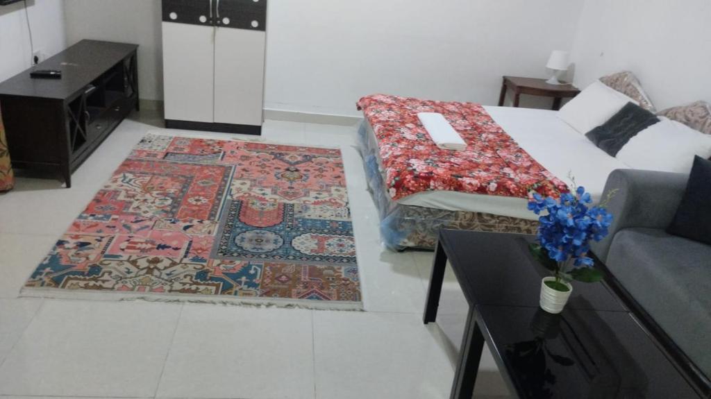a living room with a couch and a rug at Alkhuwir AlsumouTower in Muscat