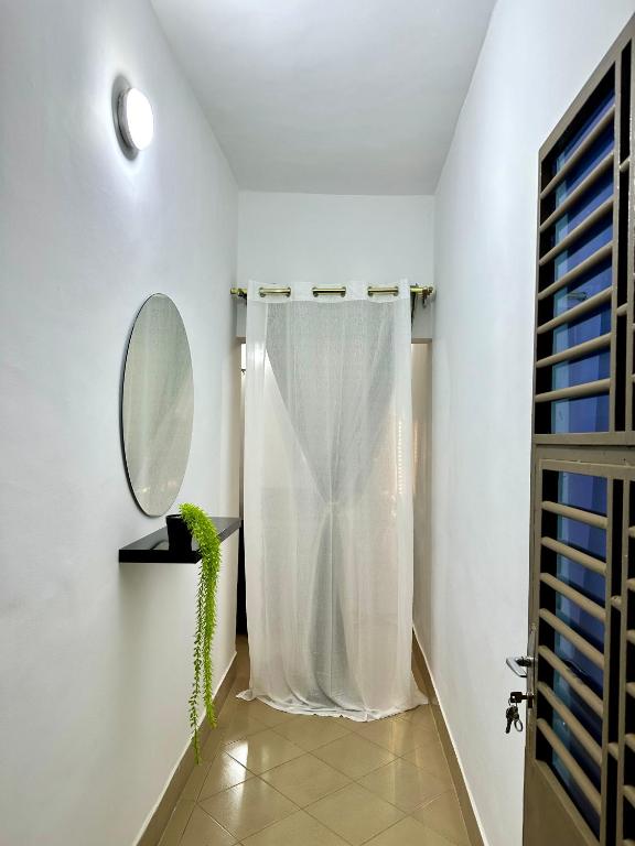 a bathroom with a white shower curtain and a mirror at Résidence Saphir-Korhogo in Korhogo