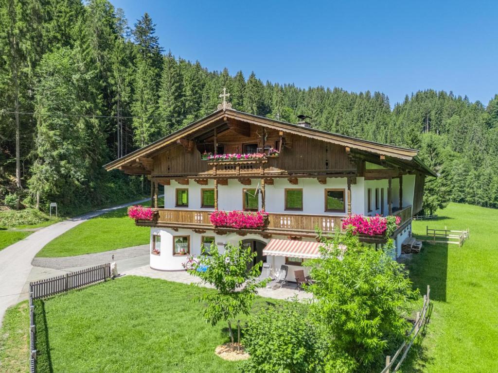 a house in the middle of a field with pink flowers at Getzfeld-Hof in Westendorf