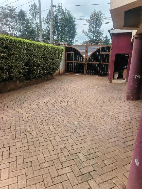 a brick driveway with a gate and a hedge at Hanita 7 Apartment in Nairobi