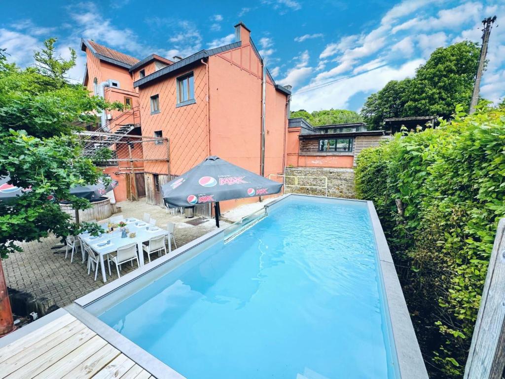 a swimming pool in the backyard of a house at Aux Berges du Lac in Jalhay