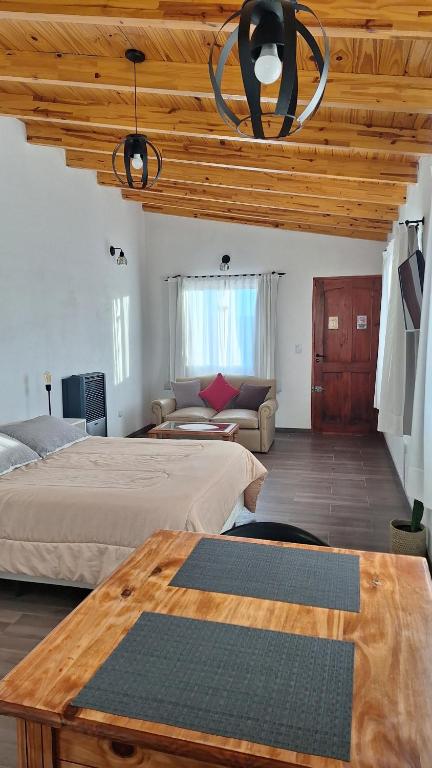 a bedroom with two beds and a table and a couch at Loft en las Sierras in Villa Giardino