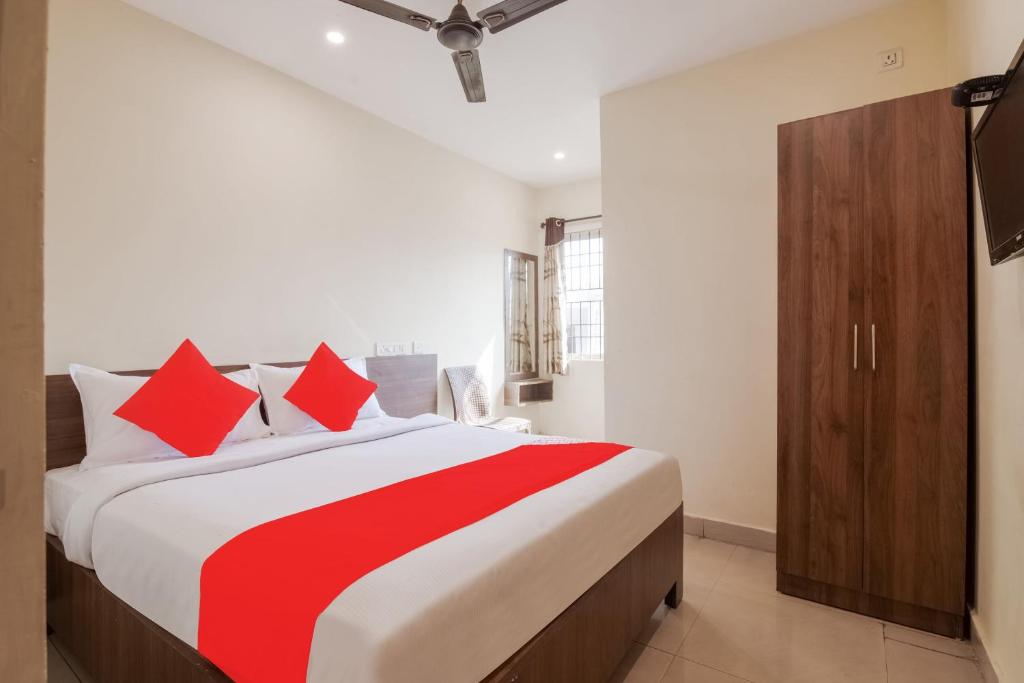 a bedroom with a large bed with red pillows at Hotel O Anu Grand in Visakhapatnam