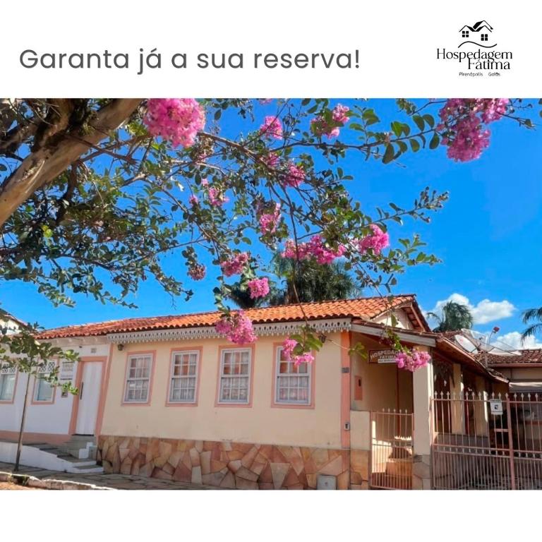 a house with pink flowers in front of it at Hospedagens da Lucia in Pirenópolis
