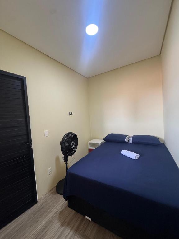 a bedroom with a blue bed and a fan at Casa da Lu in Barreirinhas