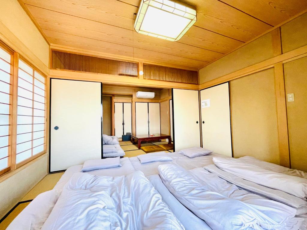 a room with four beds in a room with a ceiling at 蒼のSkyviewBase in Hiroshima