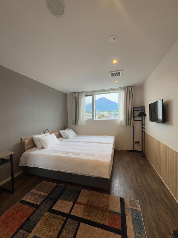 a bedroom with a large bed and a large window at Megu Fuji 2021 in Fujiyoshida