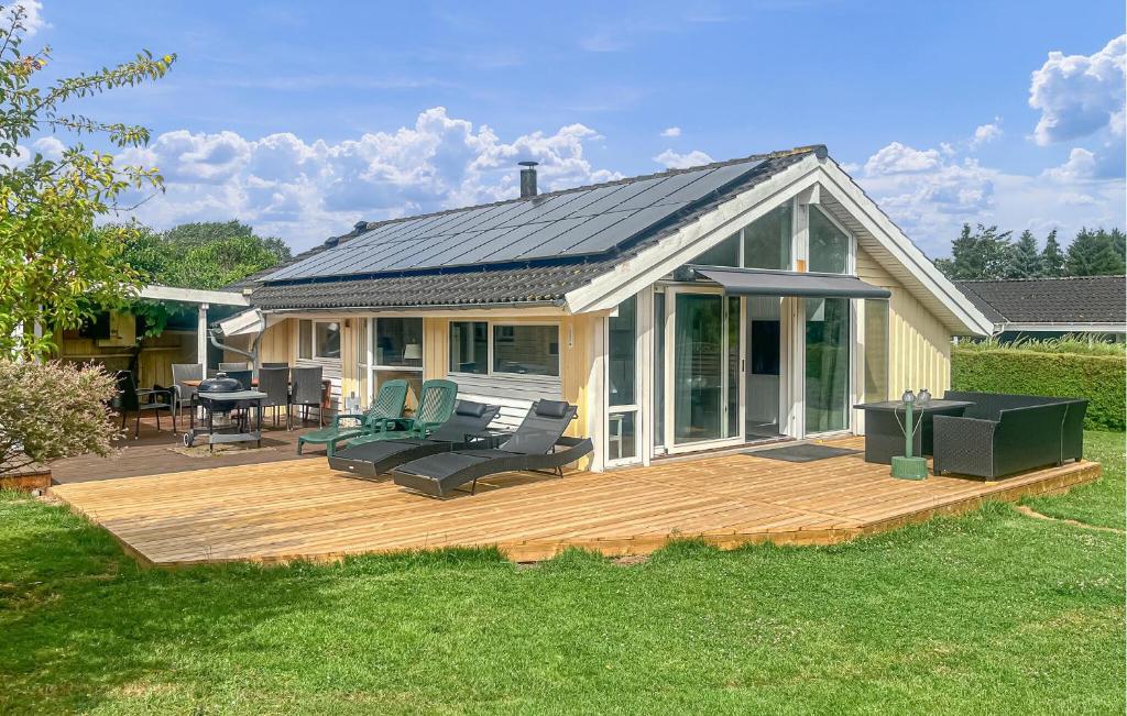 a house with a wooden deck in the yard at 4 Bedroom Cozy Home In Stege in Stege