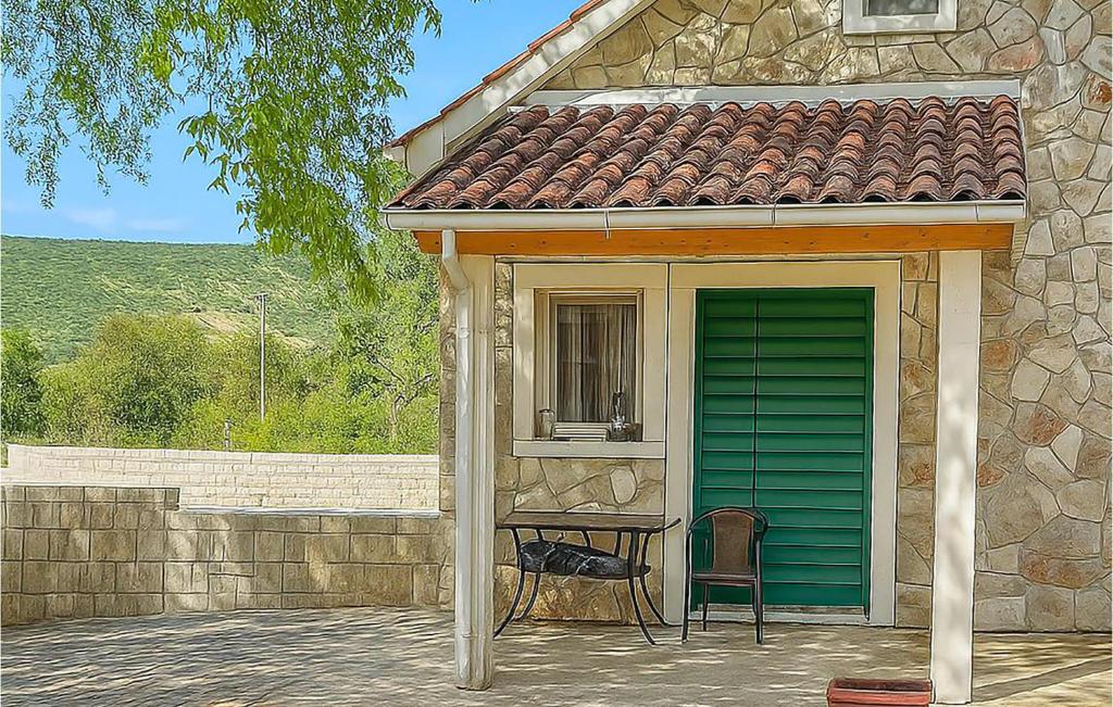 a house with a green door and a chair at Gorgeous Home In Primosten in Primošten