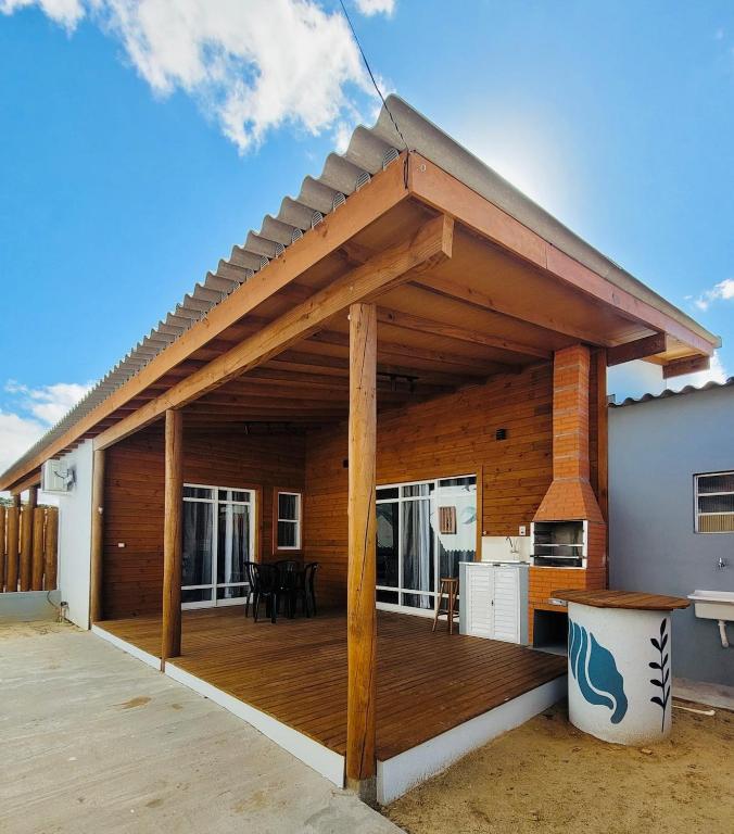 a wooden deck with a roof on a house at Casa Brisa - Las Caracolas in Rio Grande