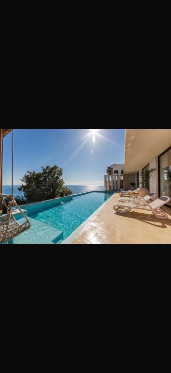 a picture of a swimming pool with lounge chairs at Panorama Villa Infinity Pool in Shëngjin