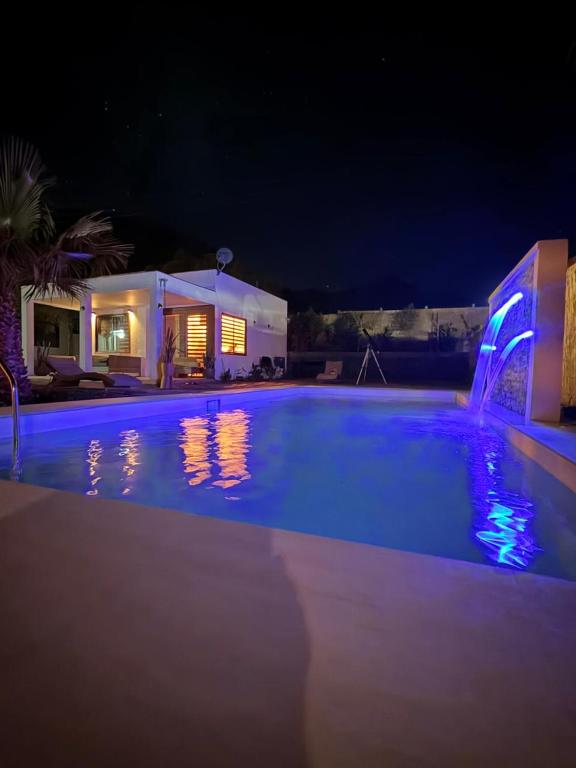 a large swimming pool at night with a house at Cabañas Torres del Sol in Vicuña