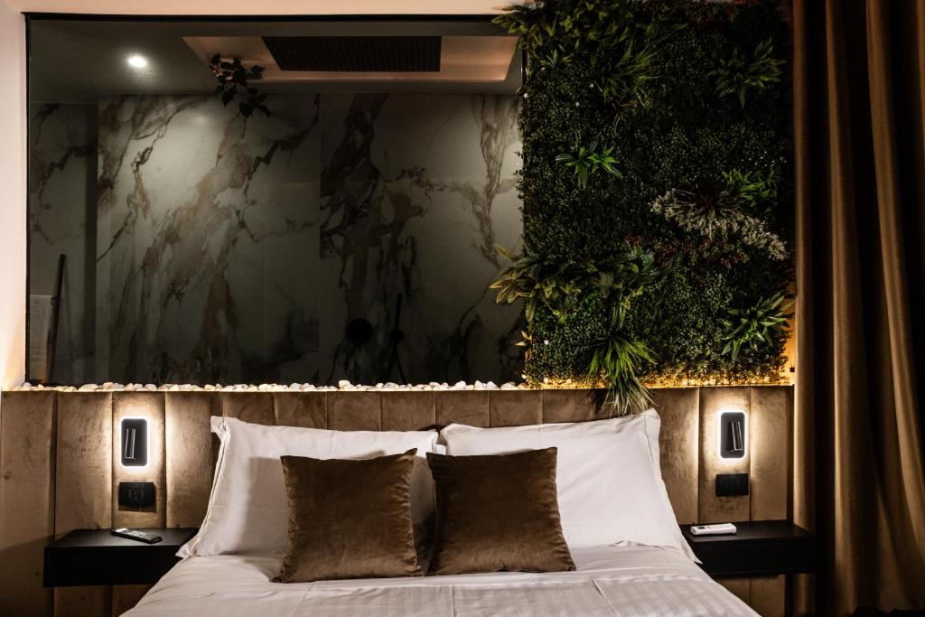 a bedroom with a bed with plants on the wall at Corsaro Etna Palace in Motta SantʼAnastasia