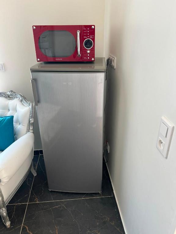 a red microwave sitting on top of a refrigerator at Résidence les Jardins Secret in Romilly-sur-Seine