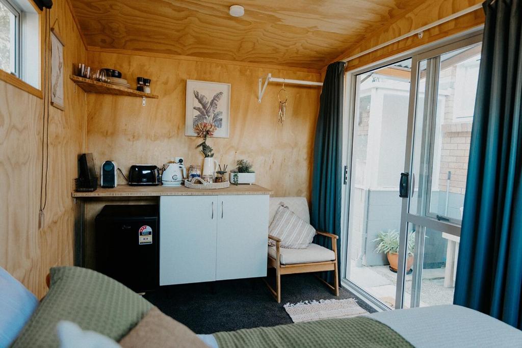 a small kitchen in a tiny house at Warm & Cosy Studio Cabin in Hamilton