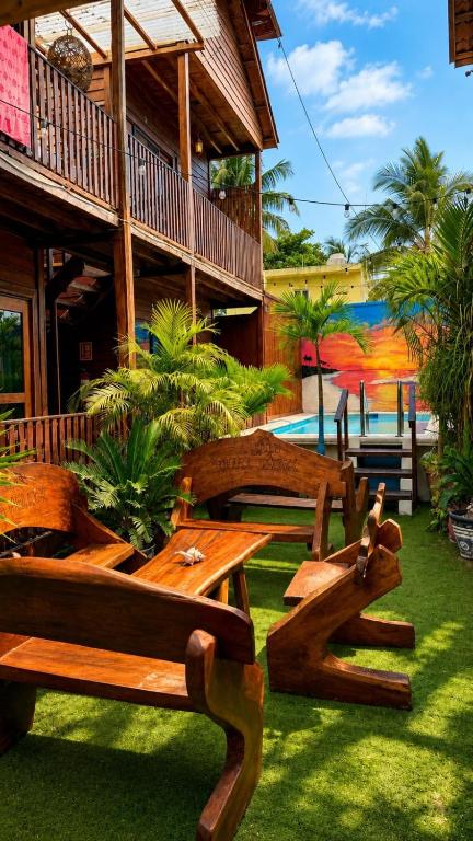 a group of wooden benches sitting outside of a building at Hotelito Villas Holbox - Self Check In in Holbox Island