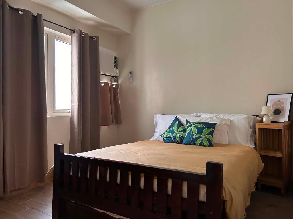 a bedroom with a bed with two pillows and a window at Sweet Escape Executive Studio at One Regis in Bacolod