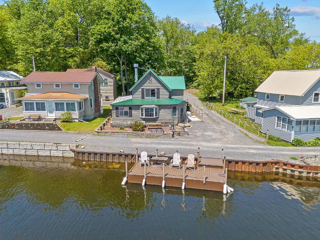 a dock with two chairs and a house on the water at Riverside Cabin with Private Fishing Access! in Pulaski