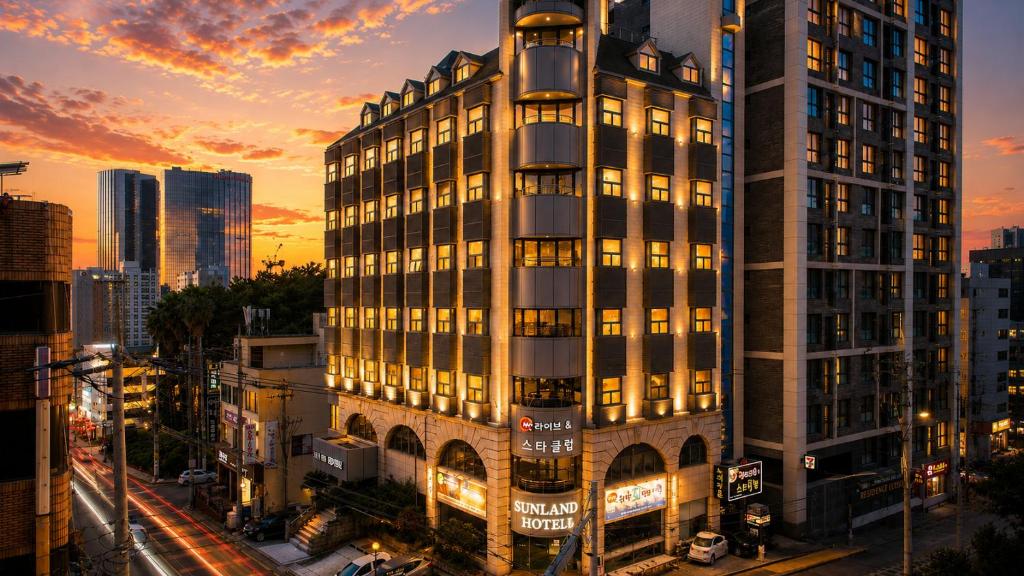 a tall building in a city at sunset at Sun Land Hotel Jeju in Jeju