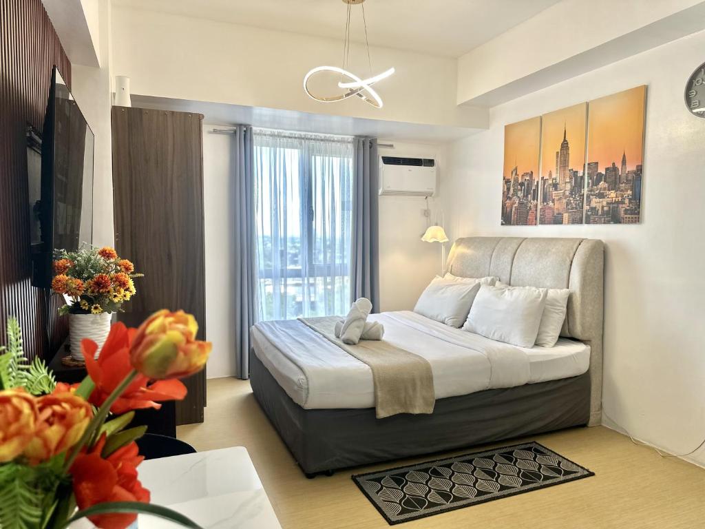 a bedroom with a bed and a large window at City View Studio Unit at Centrio Tower beside Ayala Mall in Cagayan de Oro