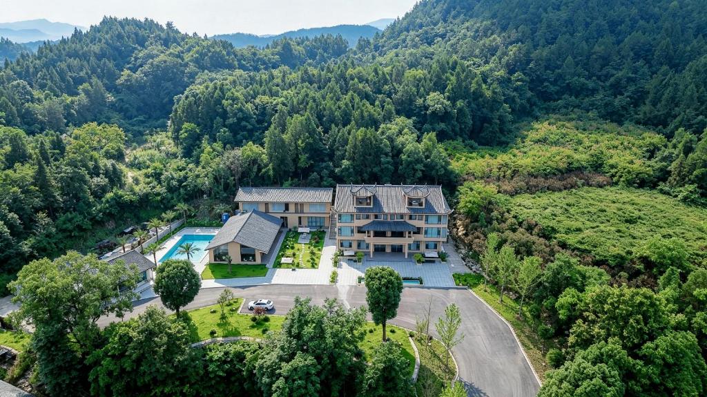 an aerial view of a house in the mountains at Chyanmu Hidden Village Retreat Near The Grand Canyon of Zhangjiajie and Yellow Dragon Cave With Local Culture Village Life Breakfast Quiet Wellness Escape for Urban Travelers Seeking Privacy and Peace in Zhangjiajie