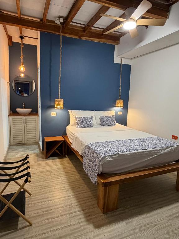 a bedroom with a bed and a blue wall at Hotel Stay Mar Baru in Cartagena de Indias