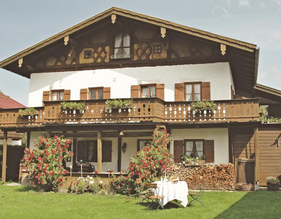 dom ze stołem i krzesłami przed nim w obiekcie Mammhofer Suite & Breakfast w mieście Oberammergau