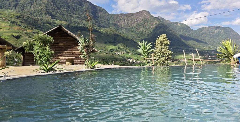 a pool of water with mountains in the background at De Mont Retreat Sapa in Sapa