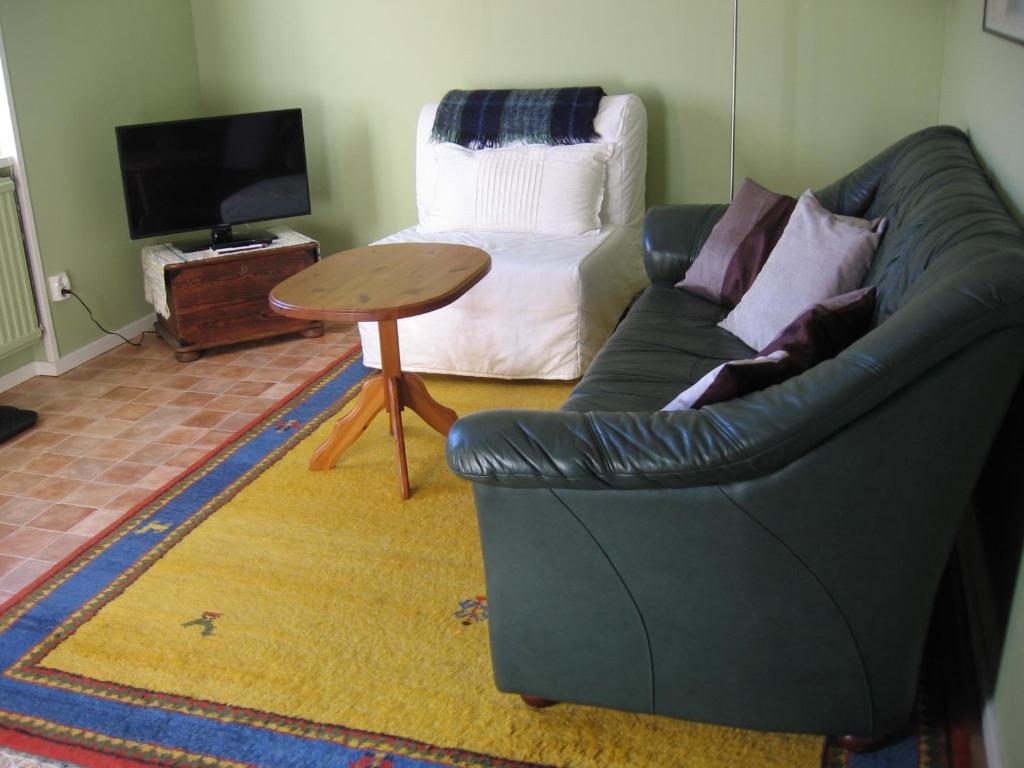 sala de estar con sofá y mesa en Dagmarsgårdens Stuguthyrningen, en Kullsbjörken