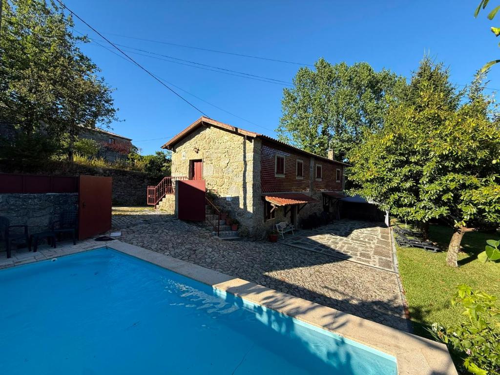 a house with a swimming pool next to a building at Casa Sequeira de São José - Gerês in Terras de Bouro