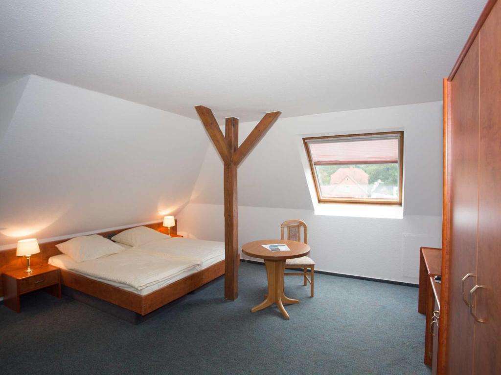 a bedroom with a bed with a cross on the wall at Hotel Zur Stemmer Post in Minden