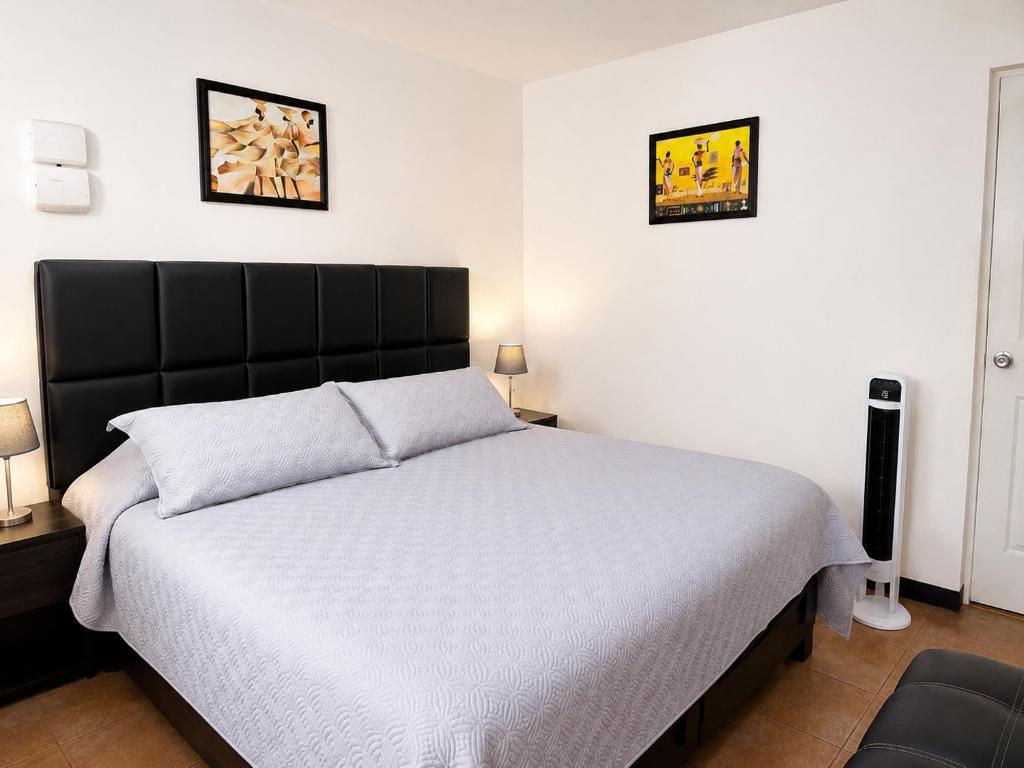 a bedroom with a bed and two pictures on the wall at Casa Postal, Loft cerca del Centro, wifi rápido y estacionamiento in Oaxaca City