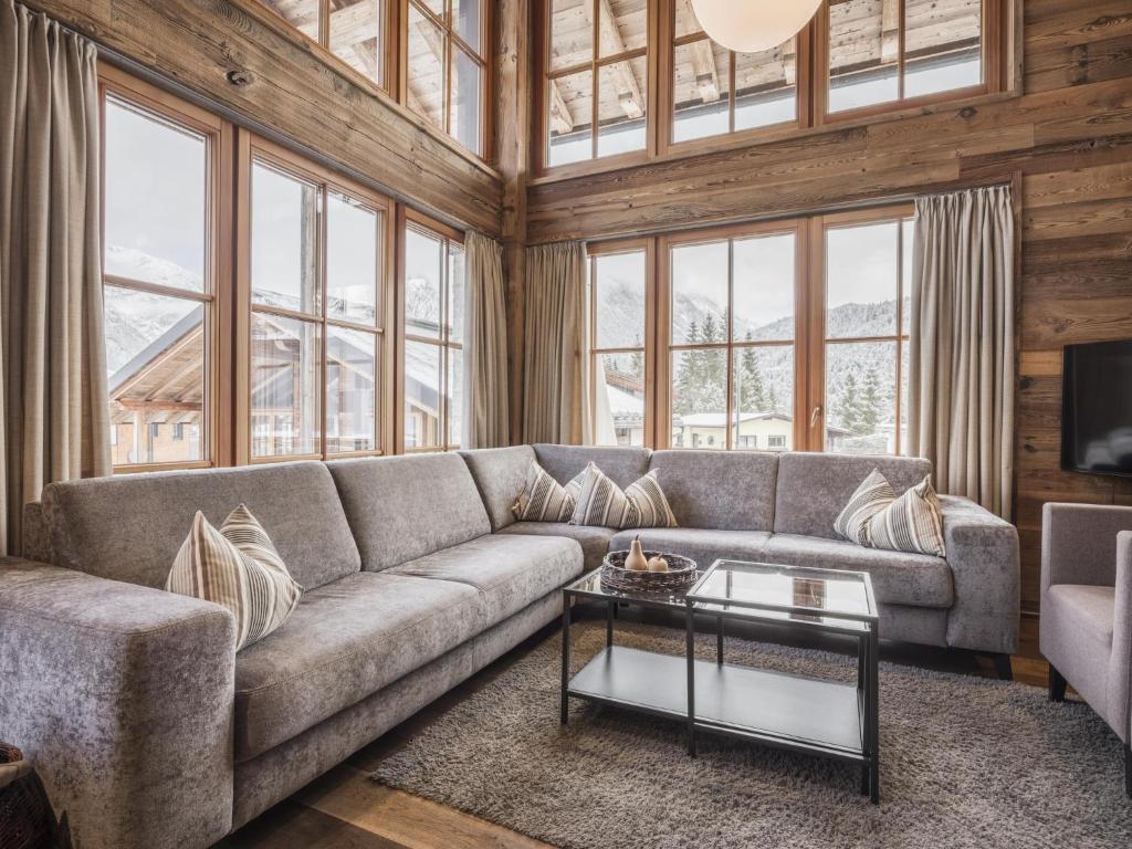 a living room with a couch and a table at Modern chalet in the willow roof in Leutasch