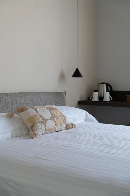 a white bed with two pillows on top of it at Zahir Rooms & Wellness srls in Trapani